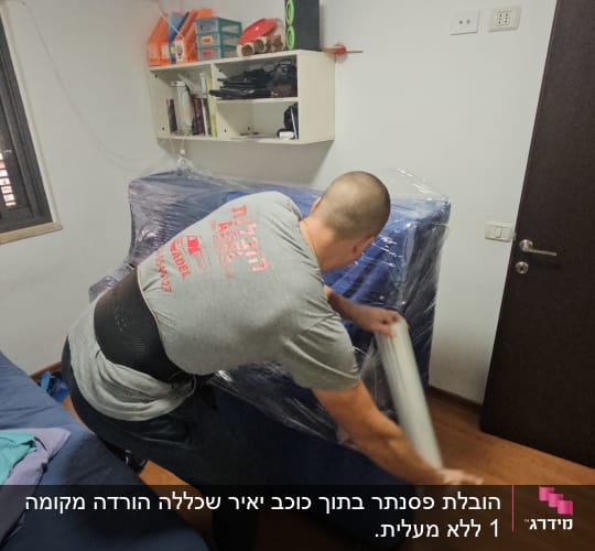 אדם עוטף רהיט בניילון לקראת מעבר דירה